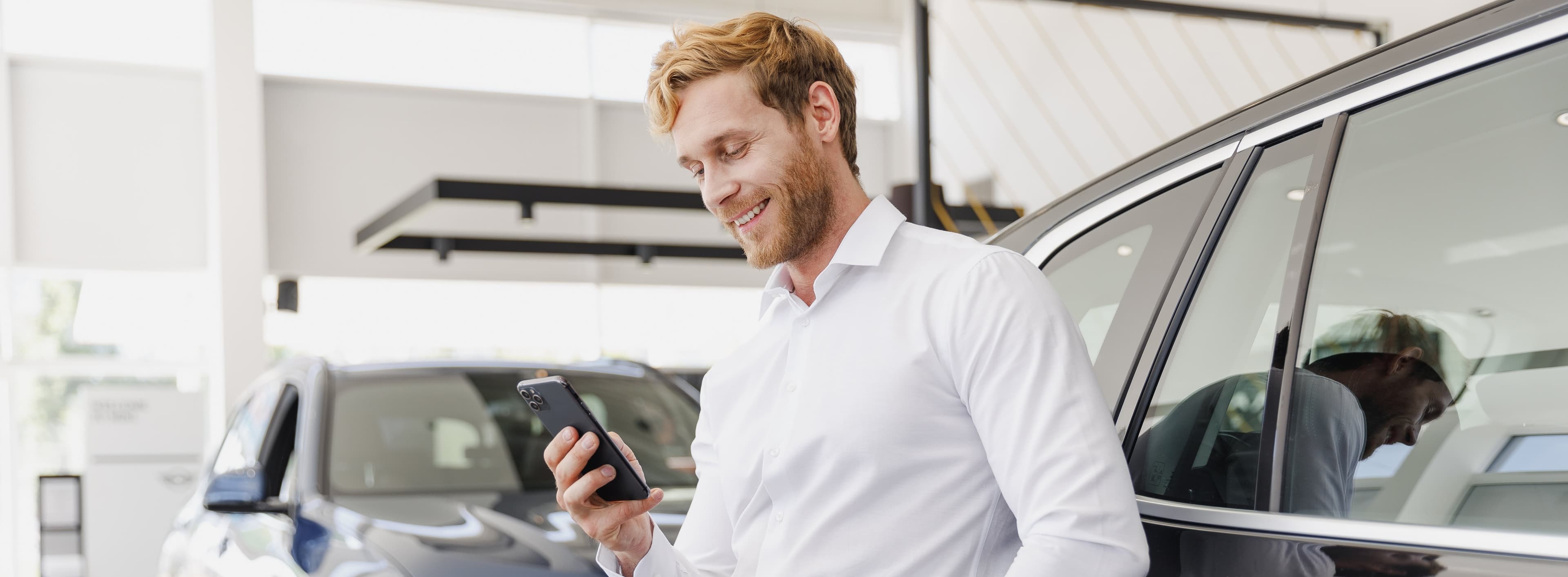Customer on the phone in a car dealership showroom