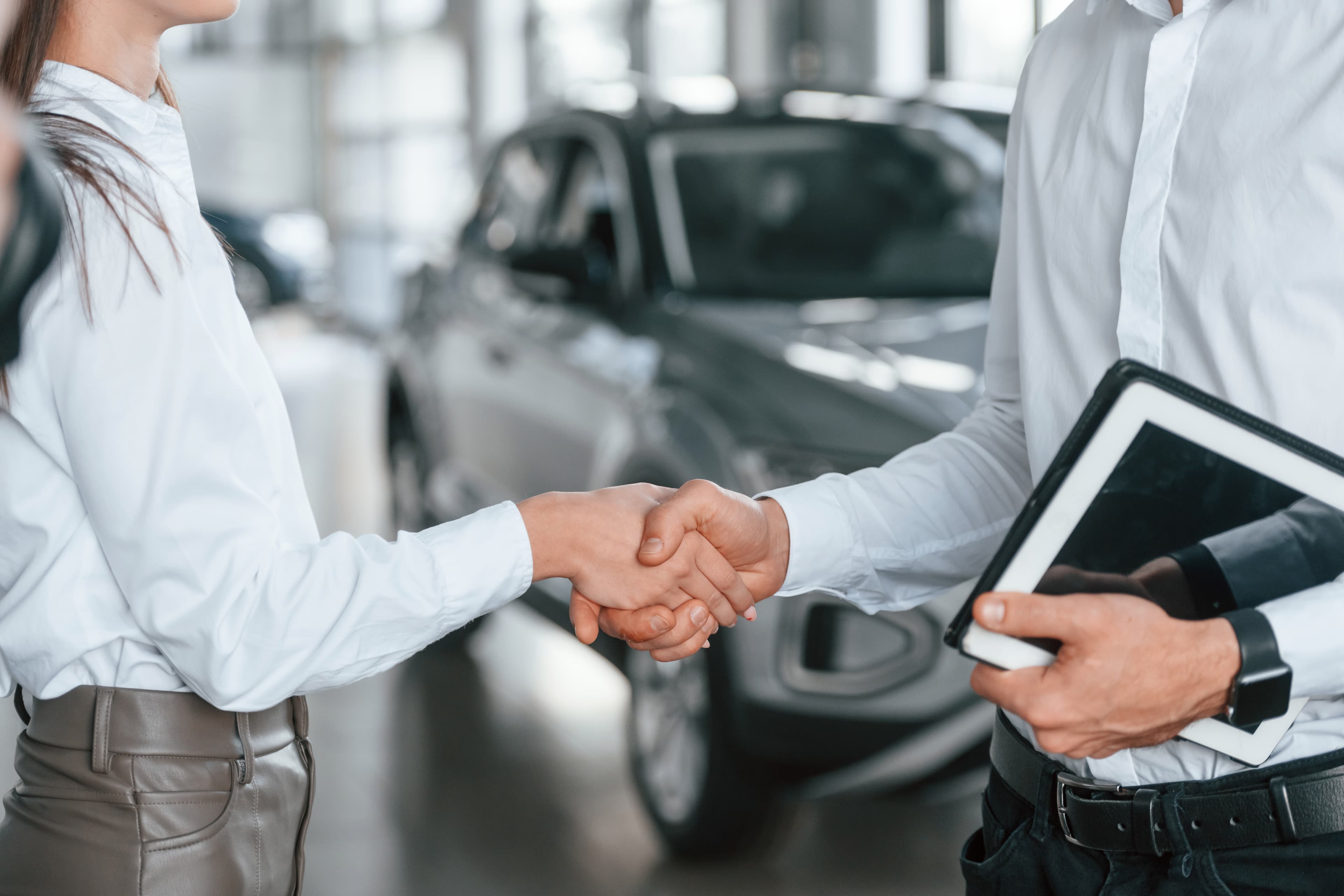 Car dealer shaking hands with a customer